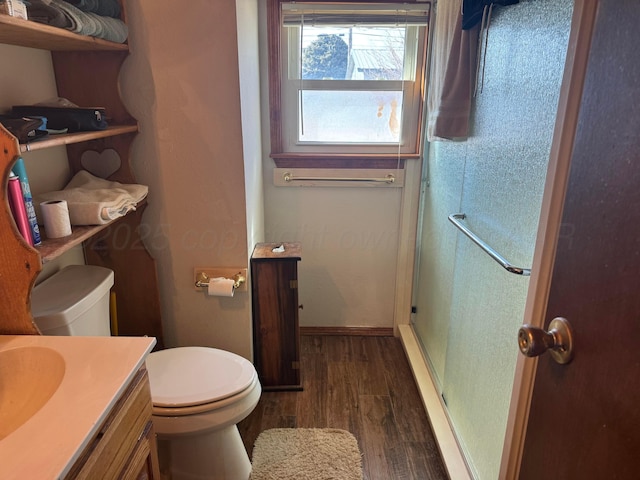 bathroom featuring a stall shower, vanity, toilet, and wood finished floors