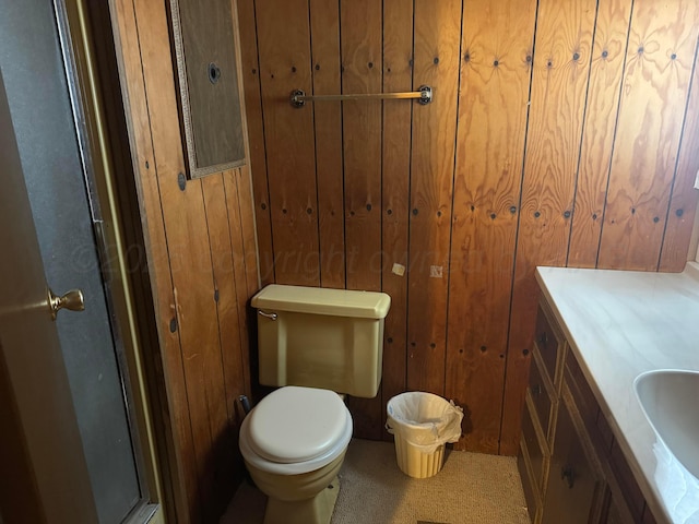 bathroom featuring toilet, wooden walls, an enclosed shower, and vanity