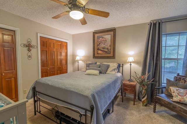 carpeted bedroom with a closet, a textured ceiling, and ceiling fan