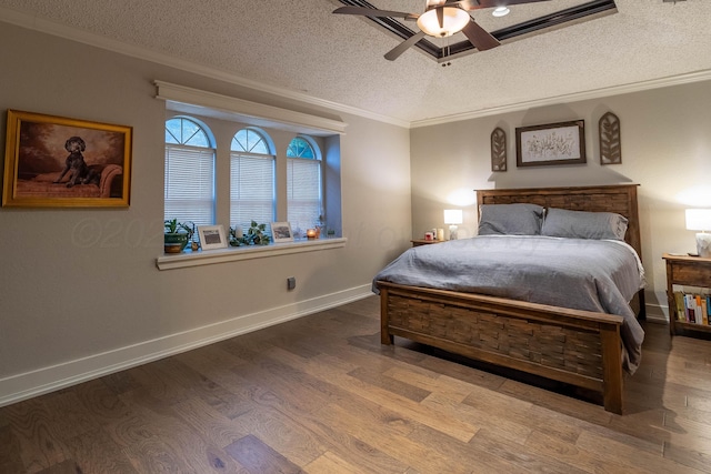 bedroom featuring ceiling fan, a textured ceiling, crown molding, and wood-type flooring