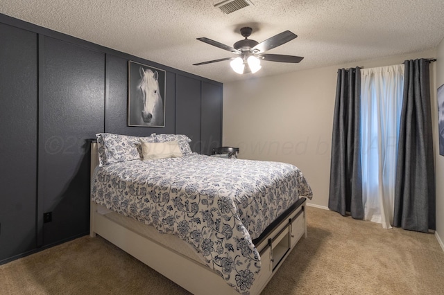 bedroom with a textured ceiling, ceiling fan, and carpet floors