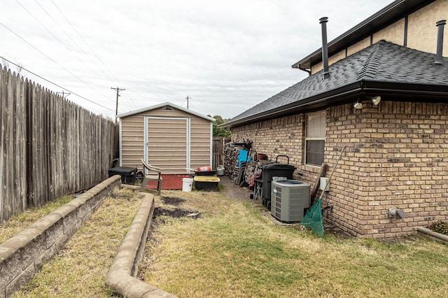 view of yard with central AC and a storage shed