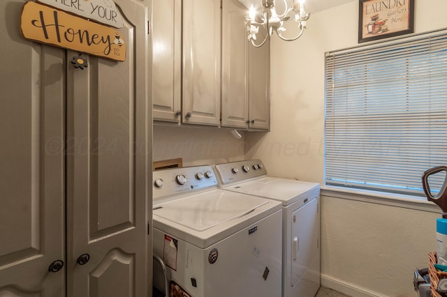 washroom with cabinets, washer and clothes dryer, and a chandelier