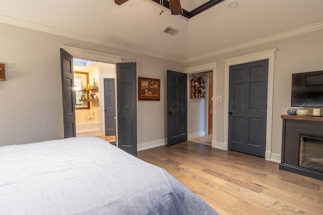 bedroom with a textured ceiling, light hardwood / wood-style floors, ornamental molding, and ceiling fan