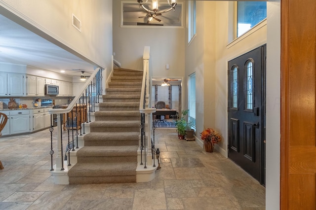 foyer entrance featuring a high ceiling and crown molding