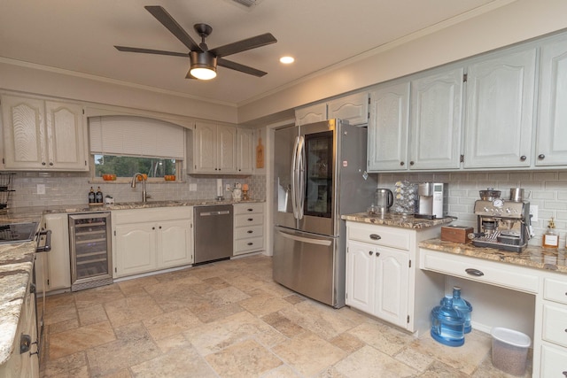 kitchen featuring sink, ceiling fan, light stone countertops, appliances with stainless steel finishes, and wine cooler