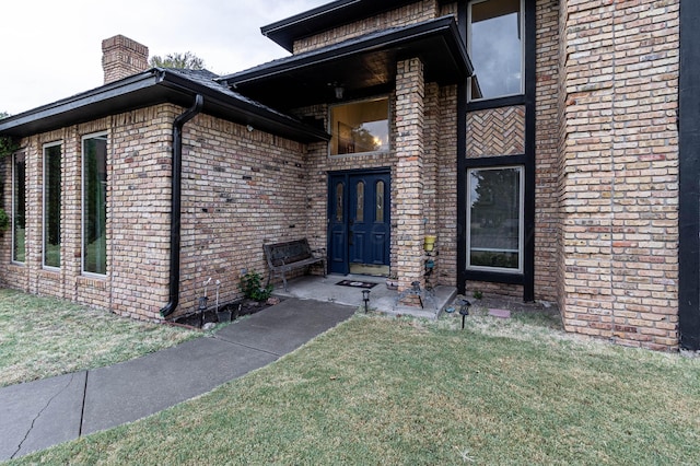 view of exterior entry featuring a yard