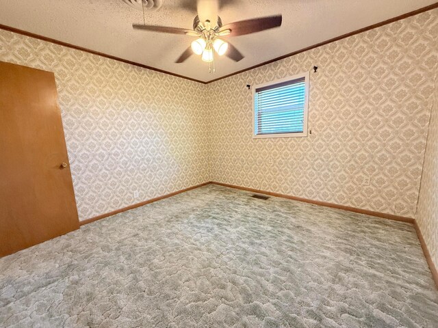 715 Ave P, Sunray, TX 79086 - spare room featuring ornamental molding, carpet floors, a ceiling fan, wallpapered walls, and a textured ceiling