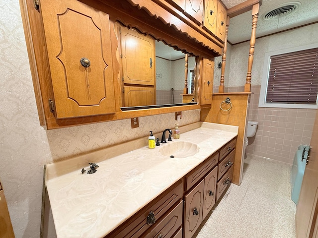 715 Ave P, Sunray, TX 79086 - full bathroom featuring vanity, toilet, wallpapered walls, and tile walls