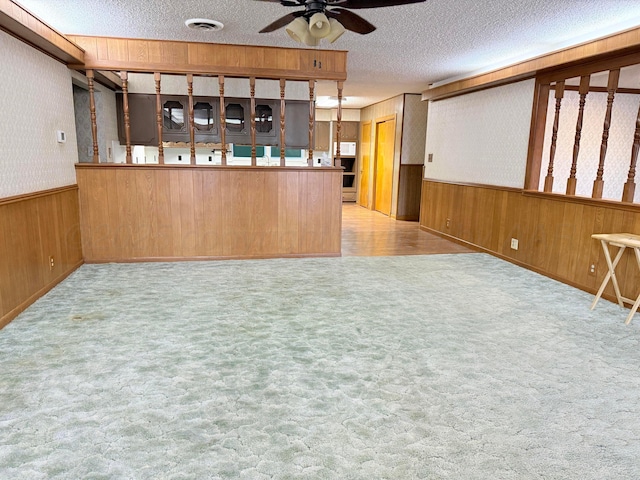 715 Ave P, Sunray, TX 79086 - bar area with a ceiling fan, wood walls, a textured ceiling, a wainscoted wall, and carpet