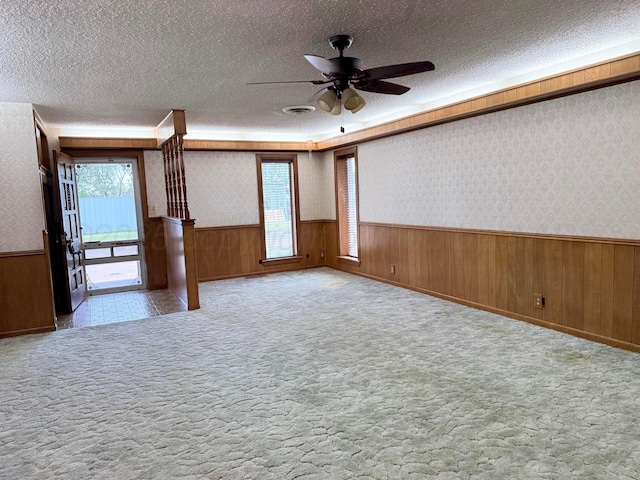 715 Ave P, Sunray, TX 79086 - unfurnished room featuring wainscoting, a textured ceiling, wallpapered walls, and ceiling fan