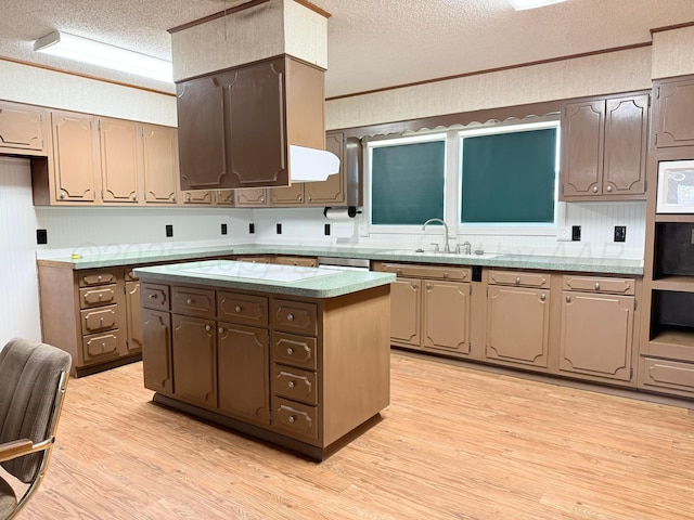 715 Ave P, Sunray, TX 79086 - kitchen featuring a textured ceiling, light wood finished floors, a sink, white microwave, and a kitchen island