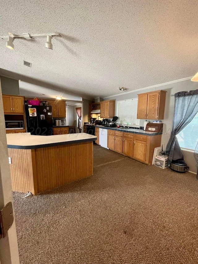 kitchen featuring black fridge, white dishwasher, kitchen peninsula, a textured ceiling, and carpet