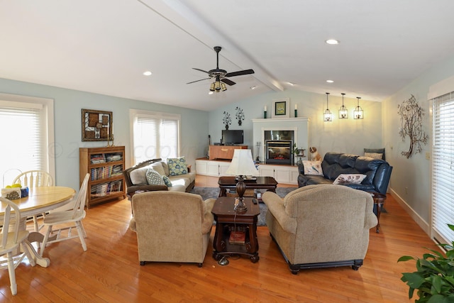 living room featuring vaulted ceiling with beams, light hardwood / wood-style flooring, and ceiling fan