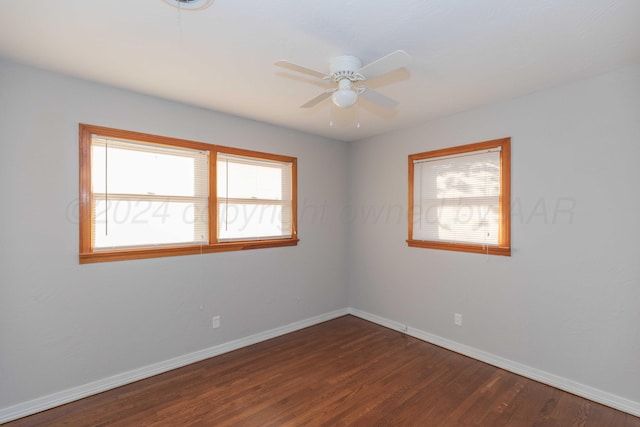 spare room featuring dark hardwood / wood-style floors, a wealth of natural light, and ceiling fan