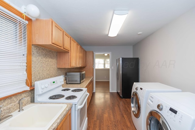 kitchen with washer and clothes dryer, dark hardwood / wood-style floors, sink, and appliances with stainless steel finishes