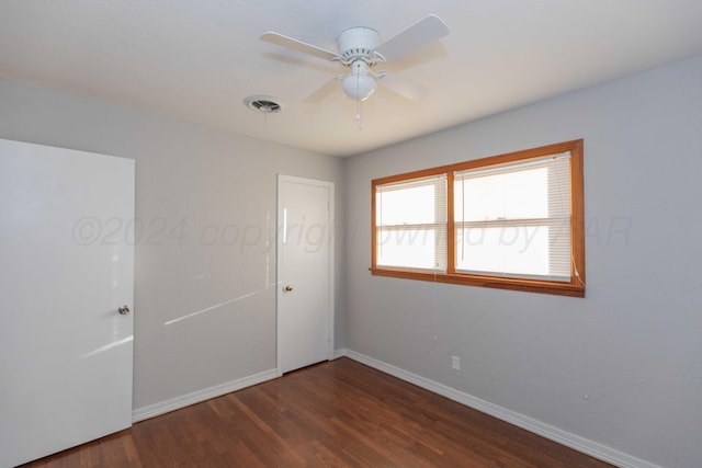 empty room featuring ceiling fan and dark wood-type flooring