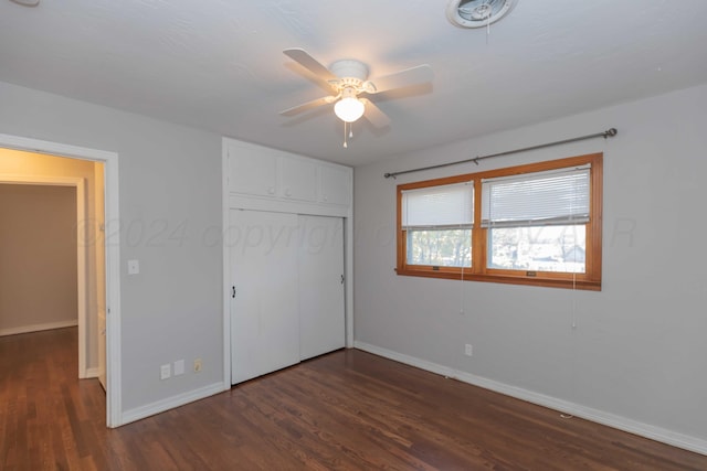 unfurnished bedroom with a closet, dark hardwood / wood-style floors, and ceiling fan