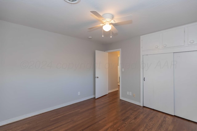 unfurnished bedroom featuring ceiling fan, a closet, and dark wood-type flooring