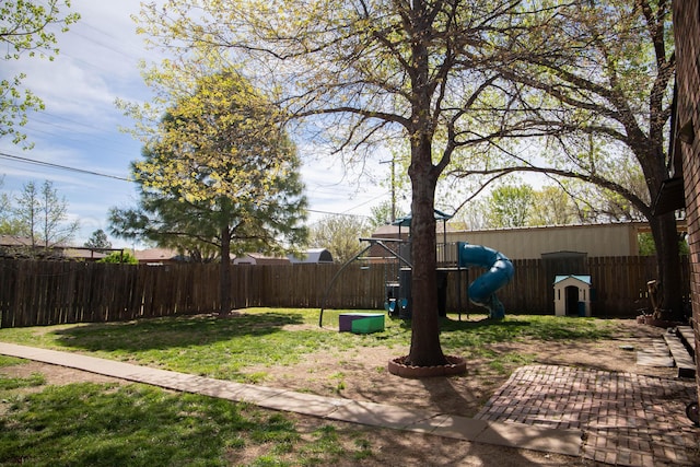 view of yard with a fenced backyard and a playground