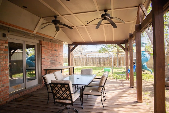 wooden terrace featuring ceiling fan, a fenced backyard, and outdoor dining area