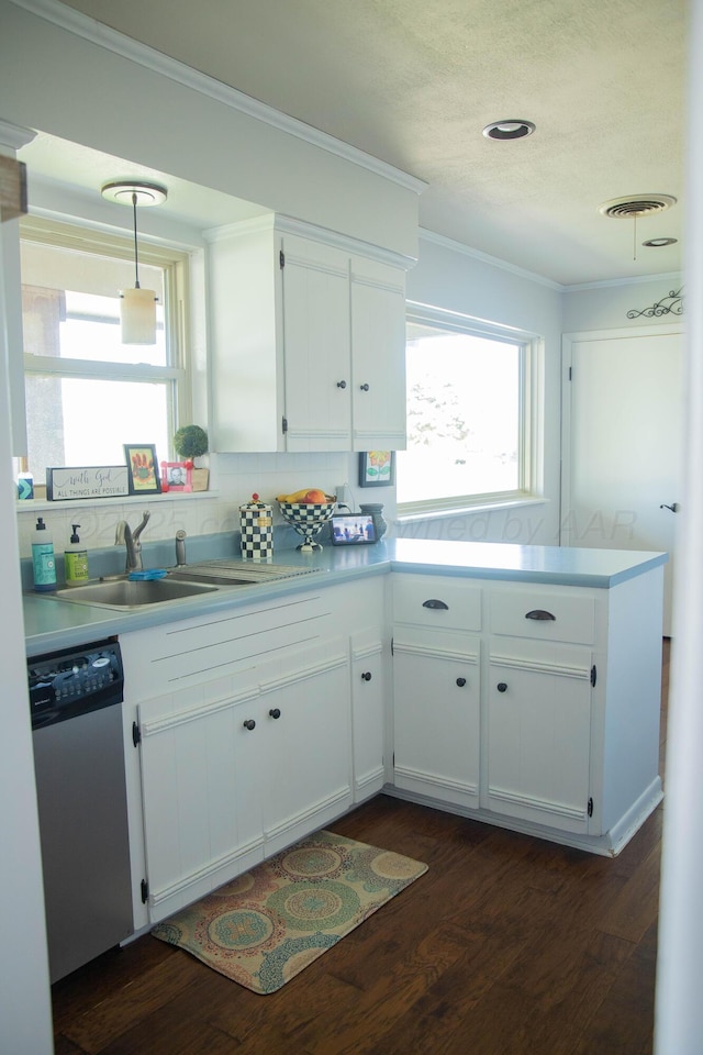 kitchen with dishwasher, visible vents, a sink, dark wood-type flooring, and crown molding