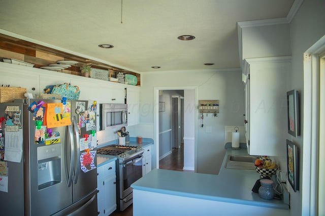 kitchen featuring decorative backsplash, a peninsula, ornamental molding, and appliances with stainless steel finishes