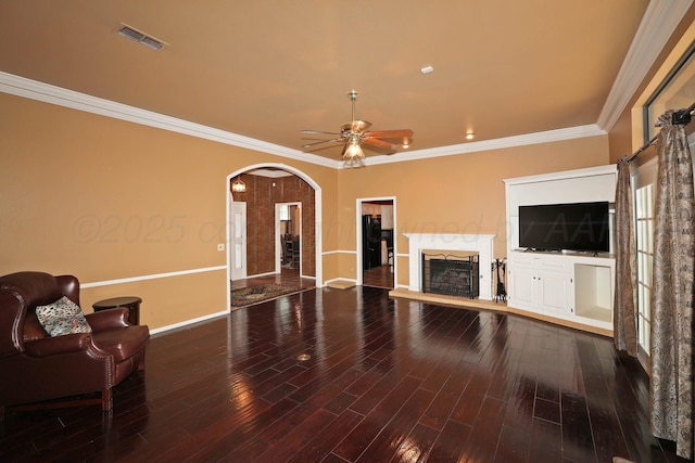 2604 Hawthorne Dr, Amarillo, TX 79109 - unfurnished living room featuring arched walkways, a fireplace, baseboards, crown molding, and ceiling fan