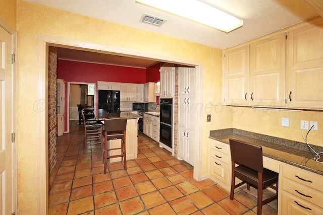 2604 Hawthorne Dr, Amarillo, TX 79109 - kitchen featuring black appliances, a kitchen bar, and a center island