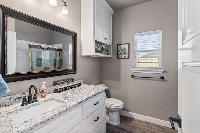 bathroom featuring hardwood / wood-style flooring, vanity, walk in shower, and toilet