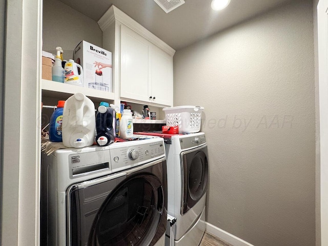 washroom with light hardwood / wood-style flooring, cabinets, and washing machine and clothes dryer