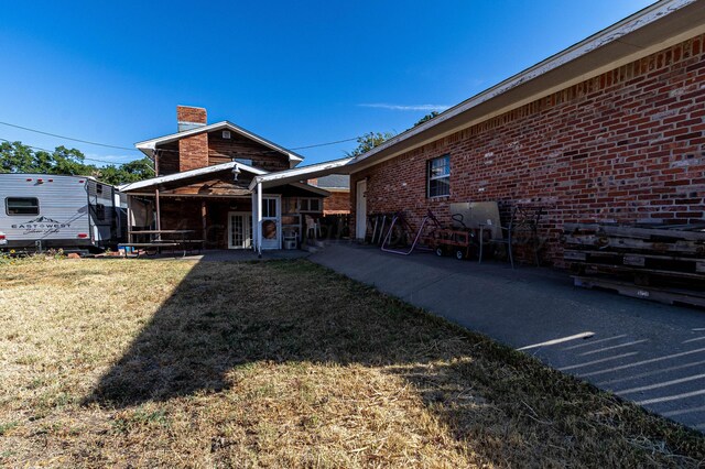 rear view of property with a yard and a patio area