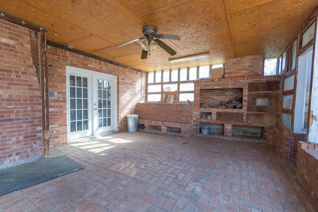 interior space featuring a fireplace, ceiling fan, and french doors