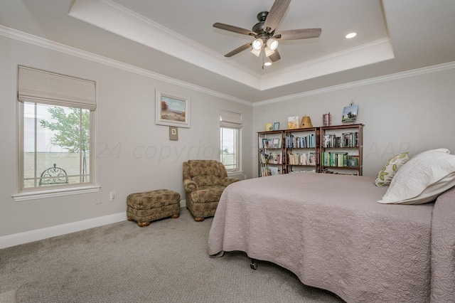 carpeted bedroom featuring a tray ceiling, ceiling fan, and ornamental molding