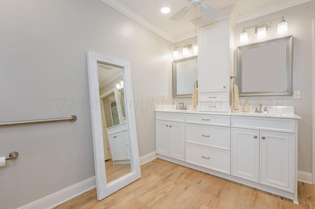 bathroom with ceiling fan, wood-type flooring, crown molding, and vanity