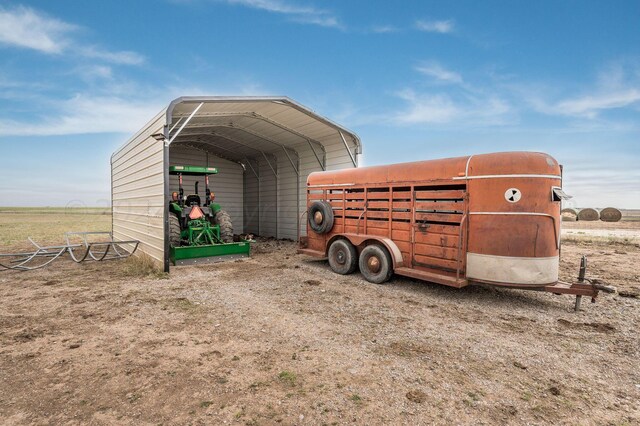 view of outbuilding featuring a rural view and a carport