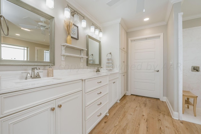 bathroom featuring wood-type flooring, vanity, ceiling fan, and crown molding