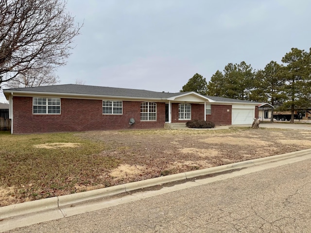 single story home featuring a garage and a front lawn