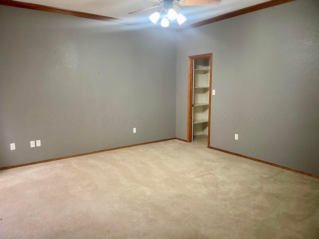 spare room featuring light carpet, ceiling fan, and ornamental molding