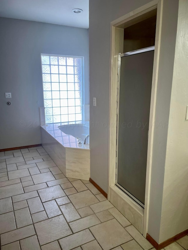 bathroom featuring shower with separate bathtub