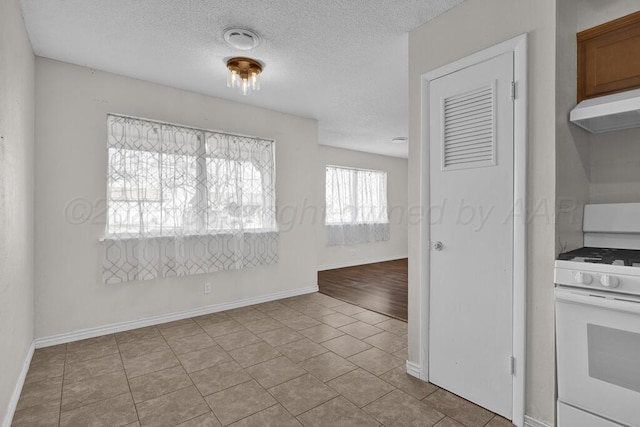 tiled spare room with a textured ceiling