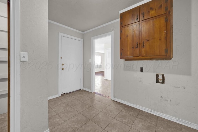 washroom featuring light tile patterned floors, crown molding, and cabinets