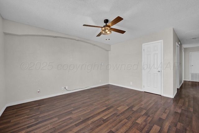 spare room featuring ceiling fan, dark wood-type flooring, and a textured ceiling