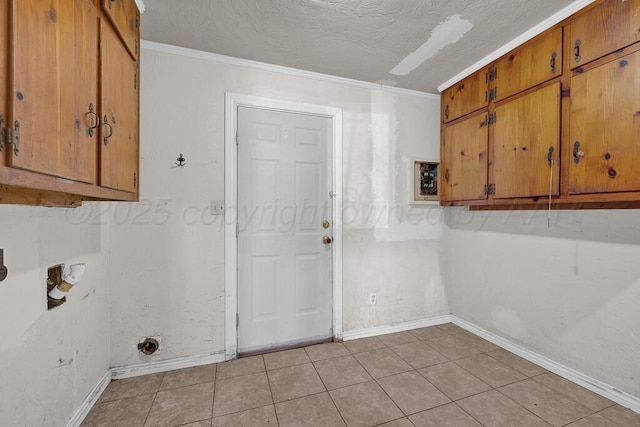 washroom with cabinets, ornamental molding, light tile patterned floors, and a textured ceiling