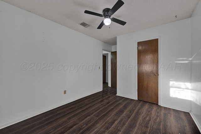 unfurnished bedroom with a ceiling fan, dark wood-style floors, and visible vents