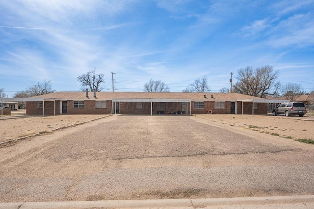 ranch-style home featuring brick siding and driveway