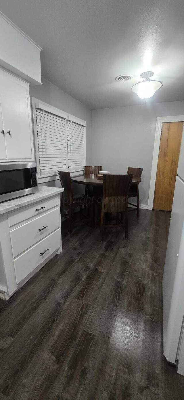 dining room with visible vents and dark wood finished floors
