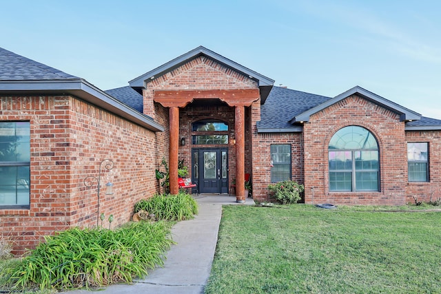 view of exterior entry featuring a yard