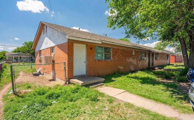 ranch-style house featuring fence, a front lawn, and brick siding