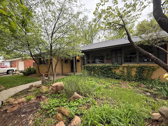 ranch-style house with brick siding and roof with shingles